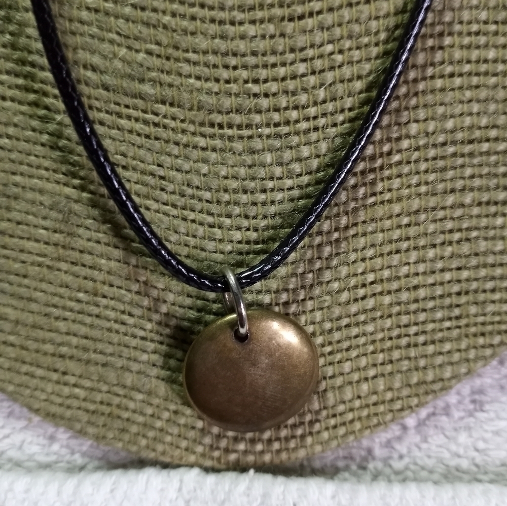 Goldtone round disk pendant on black cord necklace